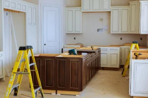 Kitchen remodeling in progress with unfinished cabinets and tools present.